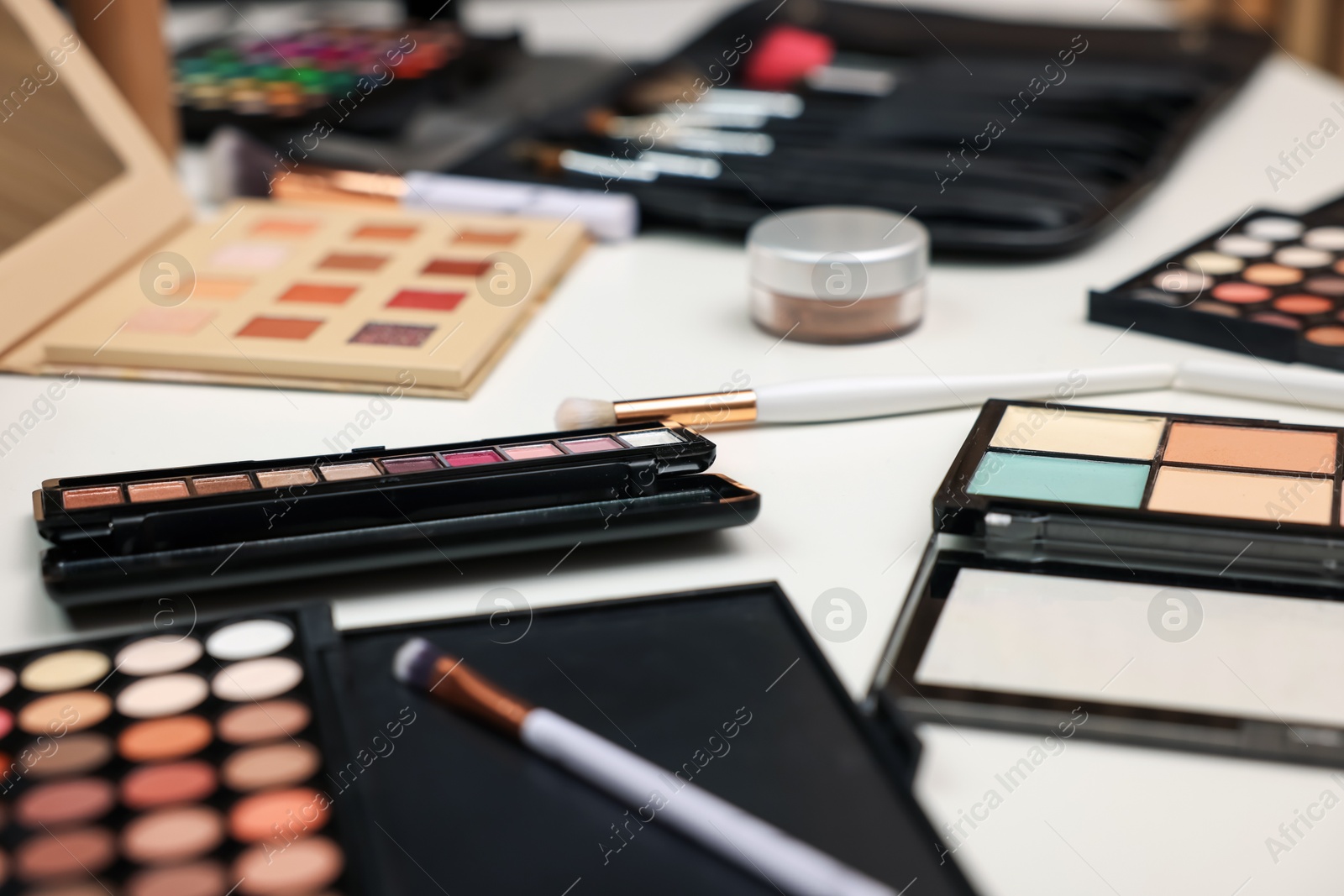 Different makeup products and brushes on dressing table, closeup Photo of Different makeup products and brushes on dressing table, closeup