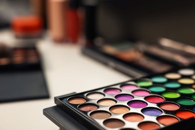 Photo of Colorful eyeshadow palette on dressing table, closeup