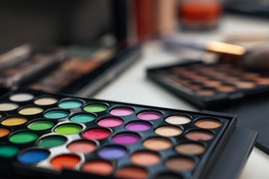 Photo of Colorful eyeshadow palette on dressing table, closeup