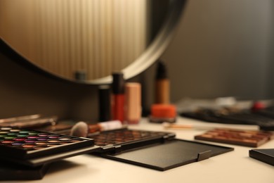 Photo of Different makeup products on dressing table, closeup