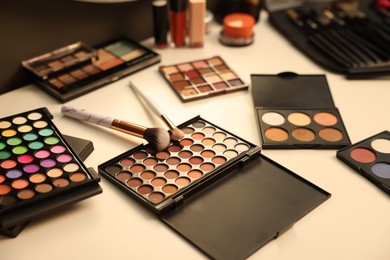 Photo of Different makeup products and brushes on dressing table, above view