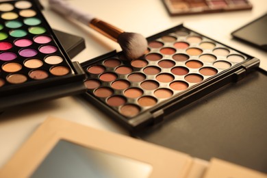 Photo of Different makeup products and brush on dressing table, closeup