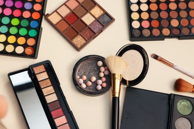 Photo of Different makeup products and brushes on dressing table, flat lay