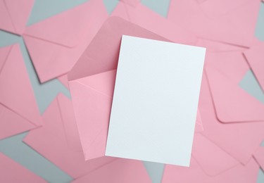 Photo of Blank invitation card and envelope on glass surface, top view. Space for design