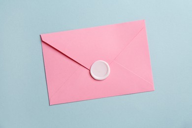 Photo of Beautiful invitation envelope with wax seal on grey background, top view