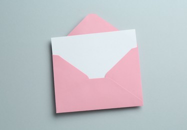 Photo of Blank invitation card and envelope on grey background, top view