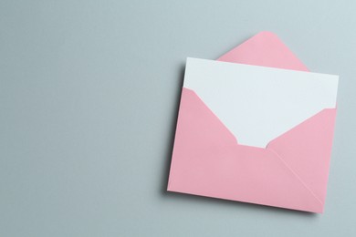 Photo of Blank invitation card and envelope on grey background, top view. Space for text
