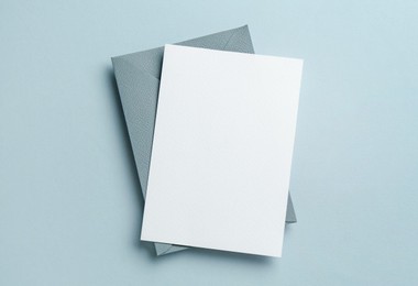 Photo of Blank invitation card and envelope on grey background, top view. Space for design