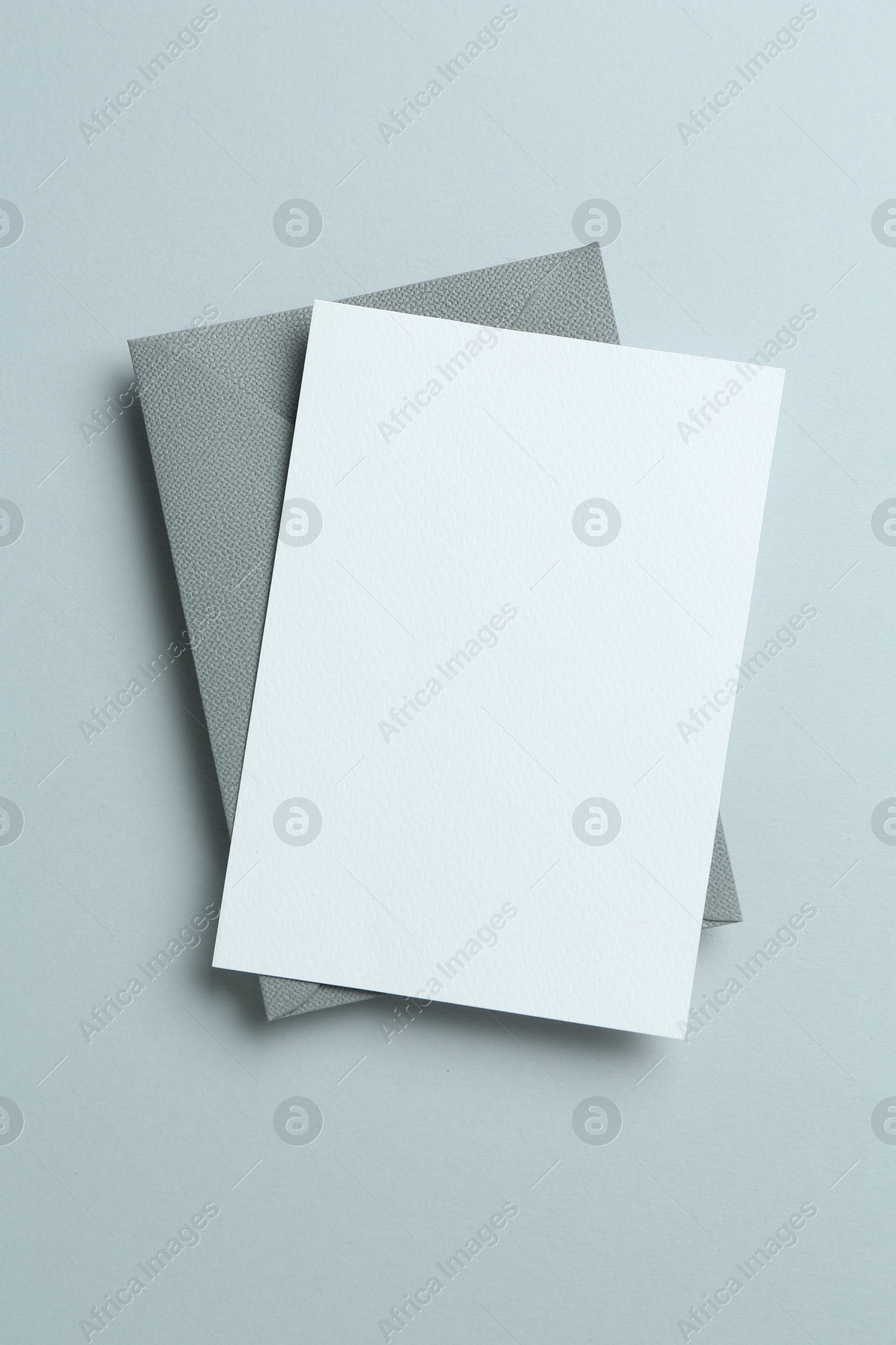 Blank invitation card and envelope on grey background, top view. Space for design Photo of Blank invitation card and envelope on grey background, top view. Space for design