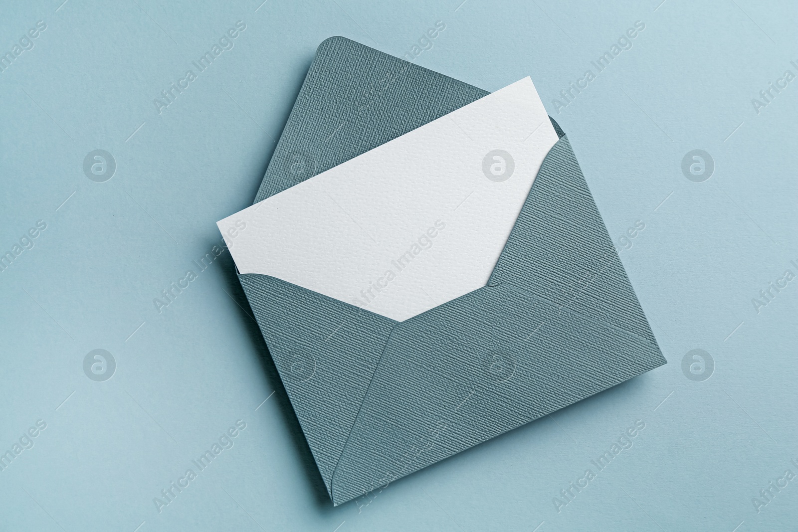 Blank invitation card and envelope on grey background, top view Photo of Blank invitation card and envelope on grey background, top view