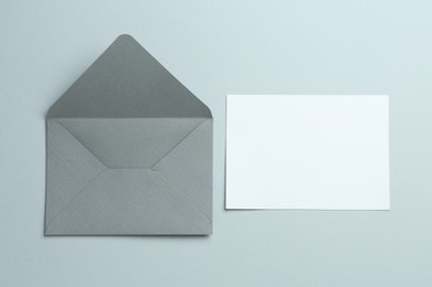 Photo of Blank invitation card and envelope on grey background, flat lay. Space for design