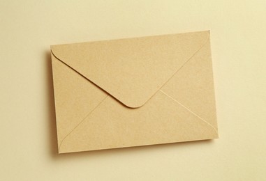 Photo of Beautiful invitation envelope on beige background, top view