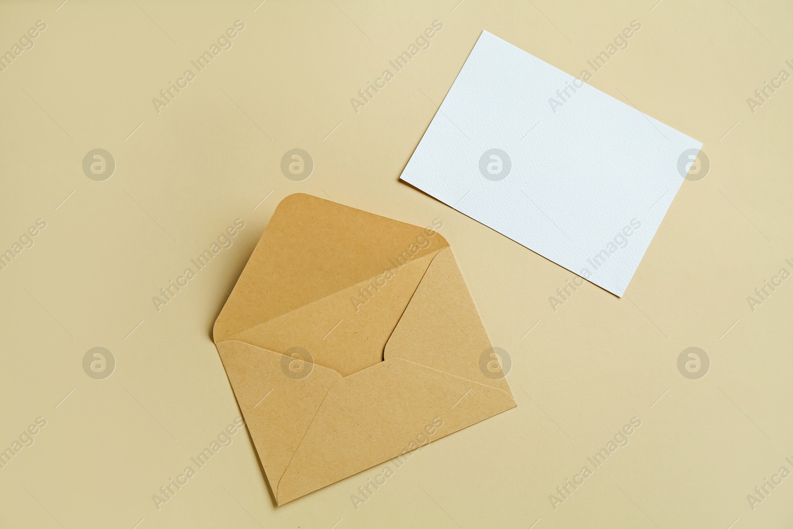 Blank invitation card and envelope on beige background, flat lay. Space for design Photo of Blank invitation card and envelope on beige background, flat lay. Space for design