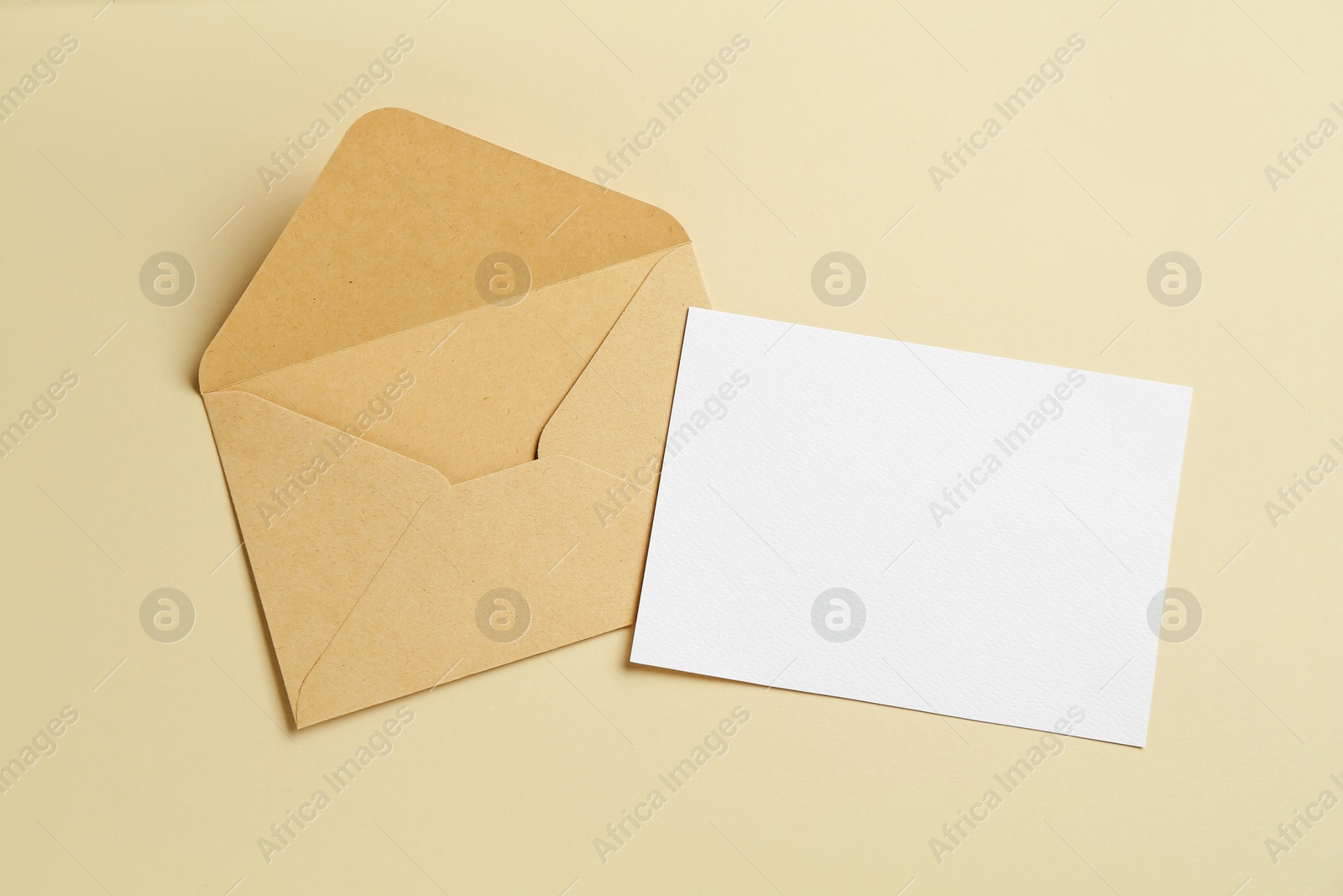 Blank invitation card and envelope on beige background, flat lay. Space for design Photo of Blank invitation card and envelope on beige background, flat lay. Space for design