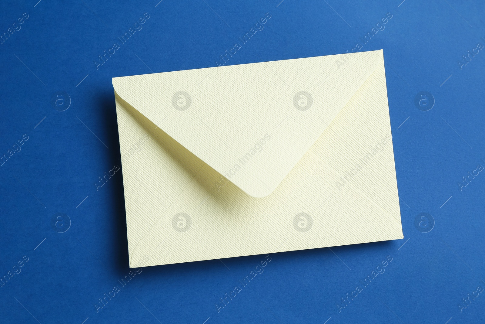 Beautiful invitation envelope on blue background, top view Photo of Beautiful invitation envelope on blue background, top view