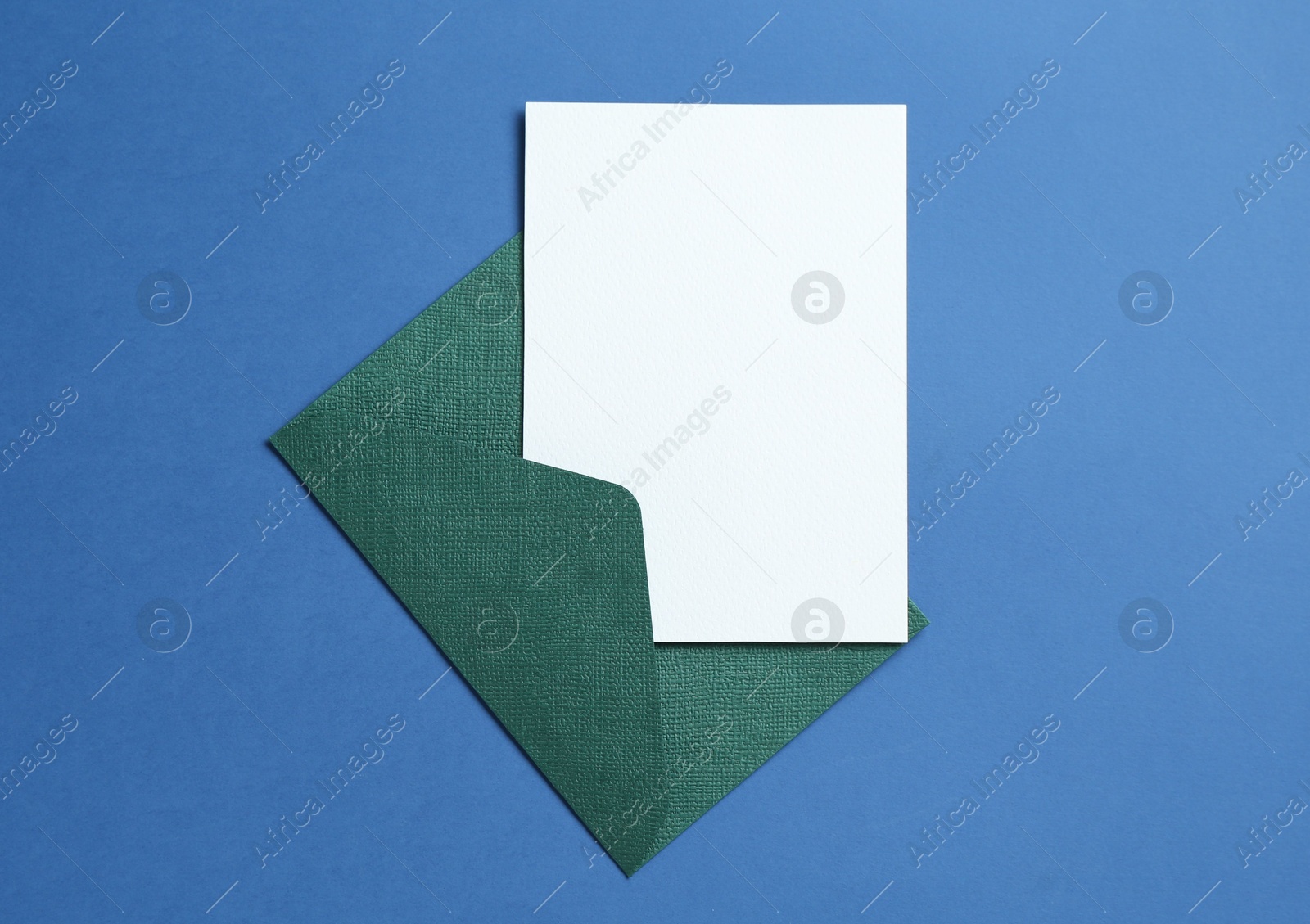 Blank invitation card and envelope on blue background, top view. Space for design Photo of Blank invitation card and envelope on blue background, top view. Space for design