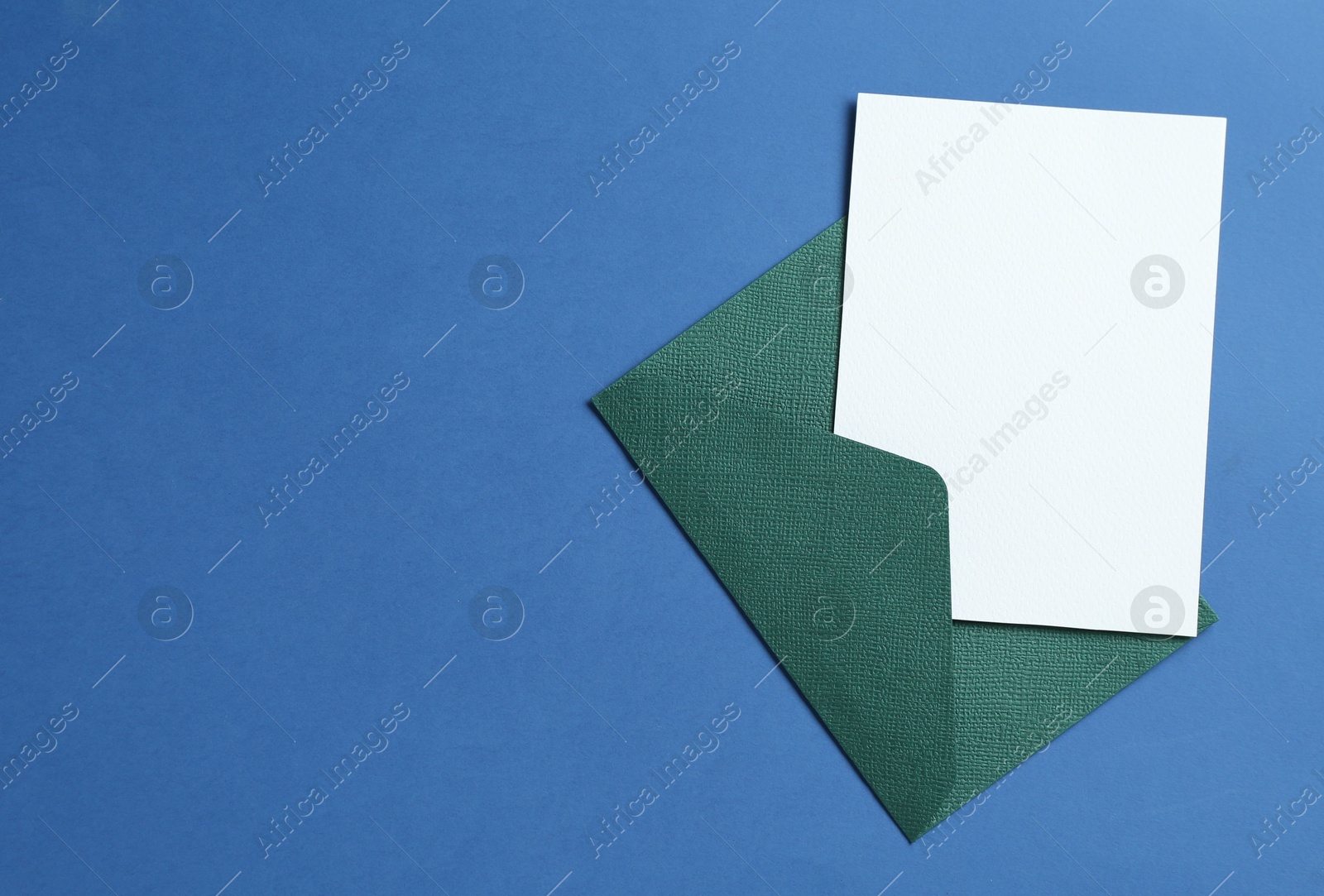 Blank invitation card and envelope on blue background, top view. Space for design Photo of Blank invitation card and envelope on blue background, top view. Space for design