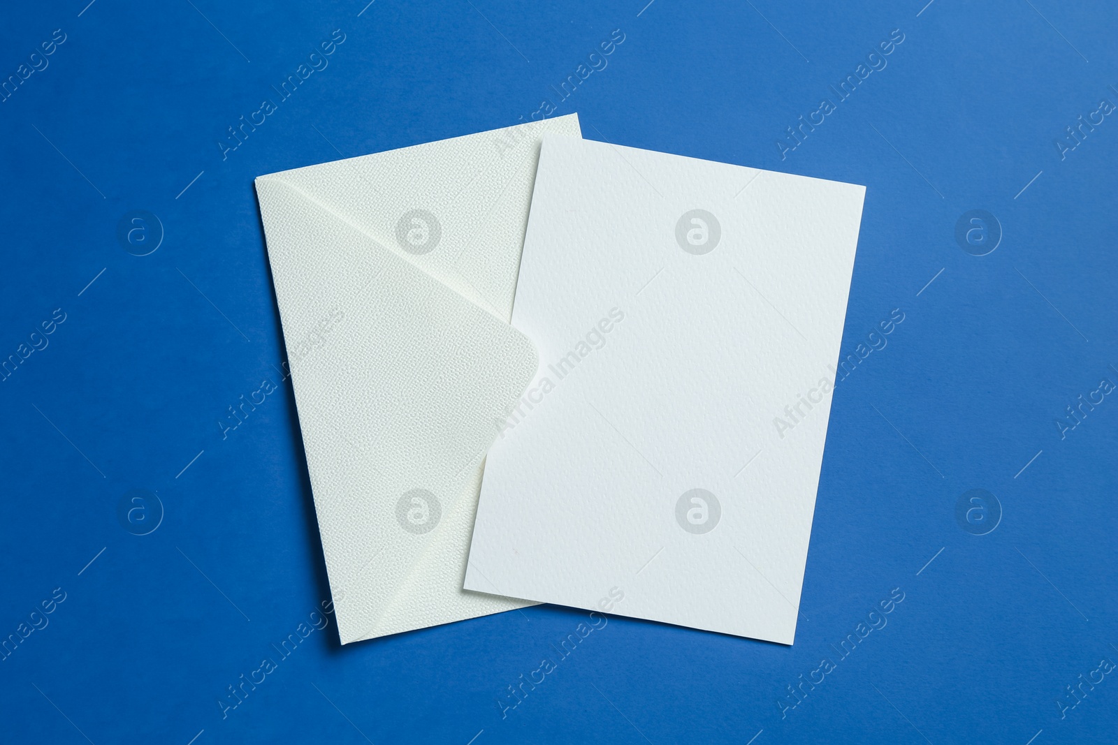 Blank invitation card and envelope on blue background, top view. Space for design Photo of Blank invitation card and envelope on blue background, top view. Space for design