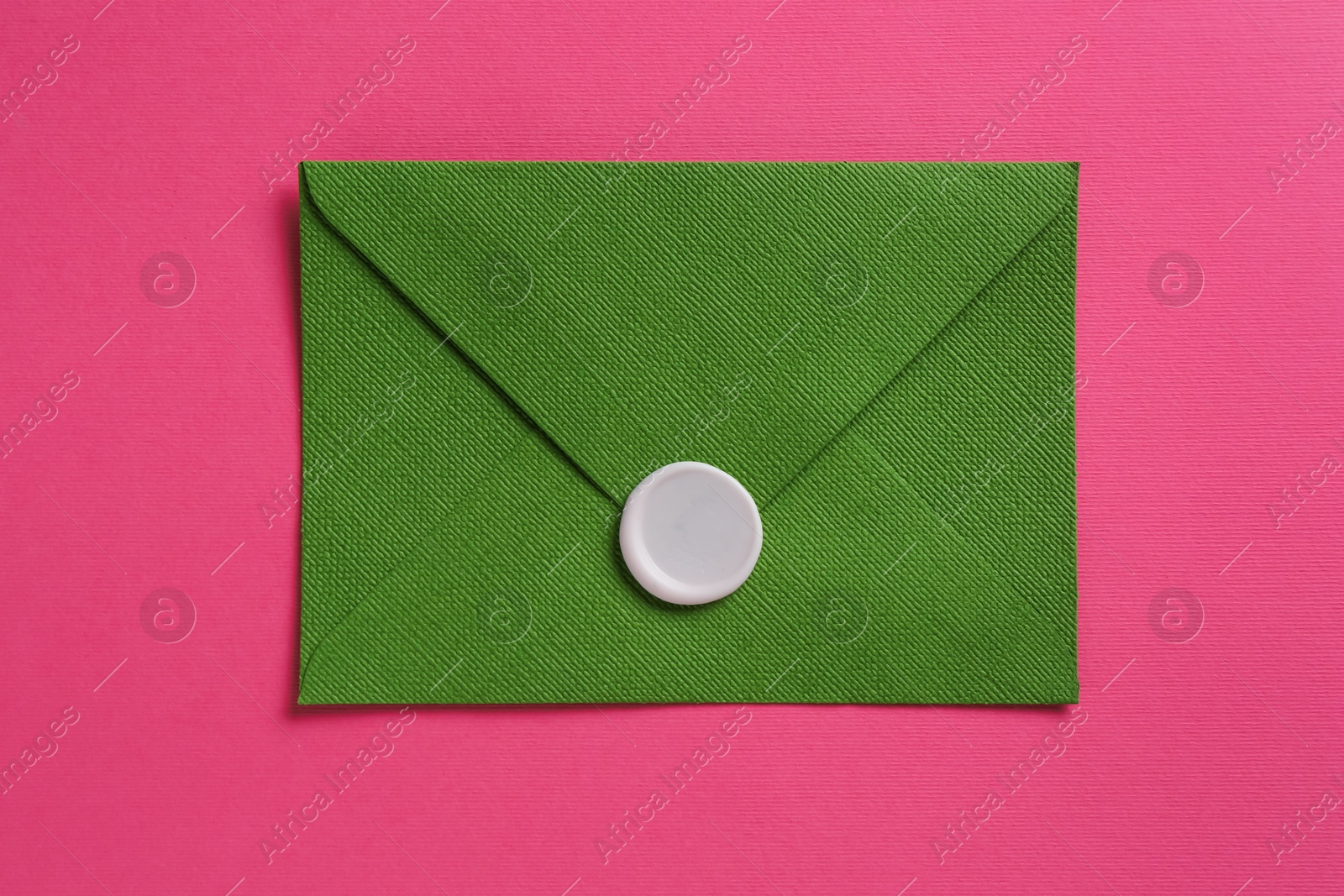 Beautiful invitation envelope with wax seal on pink background, top view Photo of Beautiful invitation envelope with wax seal on pink background, top view