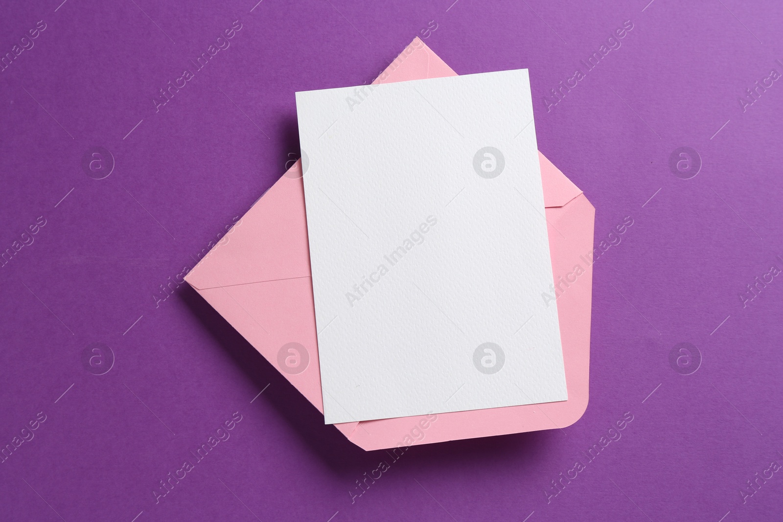 Blank invitation card and envelope on purple background, top view. Space for design Photo of Blank invitation card and envelope on purple background, top view. Space for design