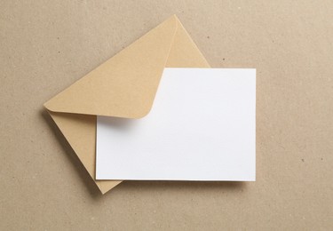 Photo of Blank invitation card and envelope on carton, top view. Space for design