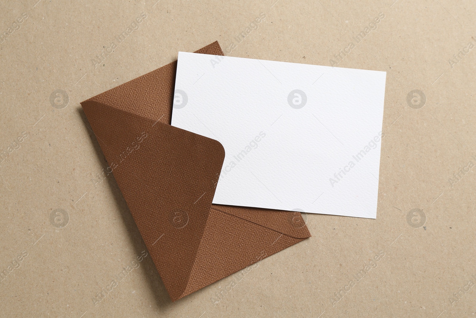 Blank invitation card and envelope on carton, top view. Space for design Photo of Blank invitation card and envelope on carton, top view. Space for design