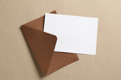 Photo of Blank invitation card and envelope on carton, top view. Space for design