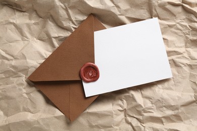 Photo of Blank invitation card and envelope on parchment paper, top view. Space for design