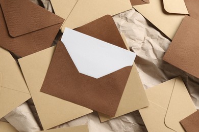 Photo of Blank invitation card and envelopes on parchment paper, flat lay