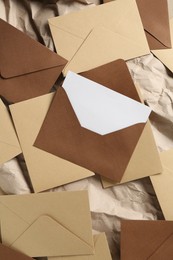 Photo of Blank invitation card and envelopes on parchment paper, flat lay