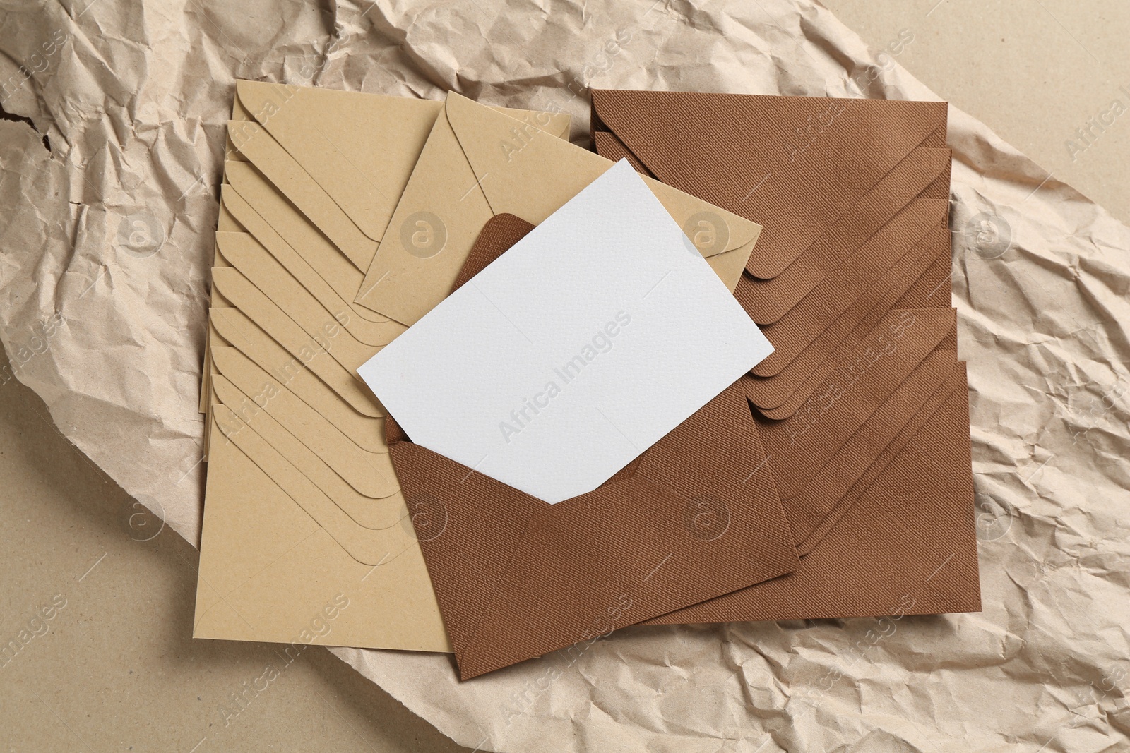 Blank invitation card, envelopes and parchment paper on carton, top view. Space for design Photo of Blank invitation card, envelopes and parchment paper on carton, top view. Space for design