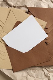 Photo of Blank invitation card, envelopes and parchment paper on table, top view. Space for design