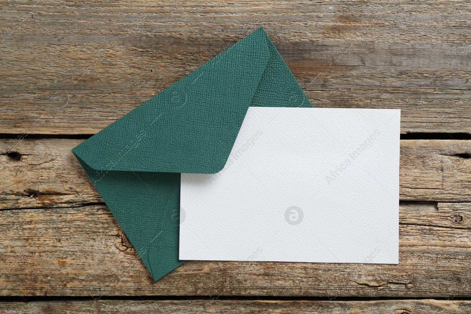 Blank invitation card and envelope on wooden table, top view. Space for design Photo of Blank invitation card and envelope on wooden table, top view. Space for design