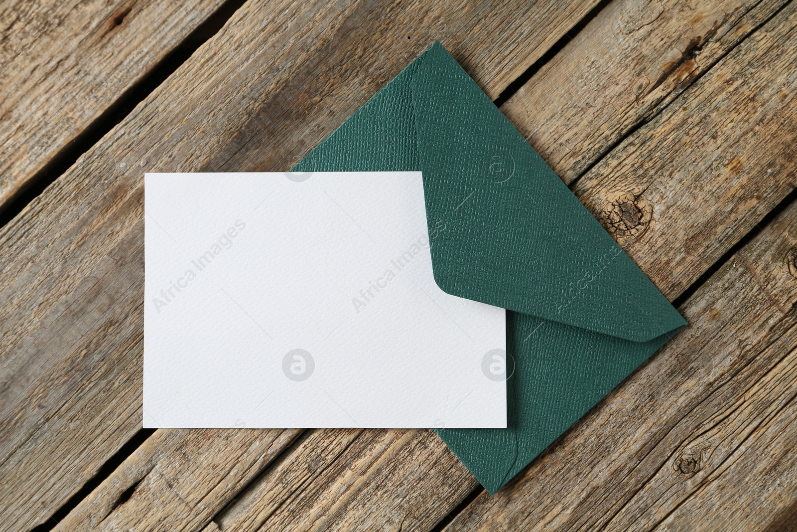 Blank invitation card and envelope on wooden table, top view. Space for design Photo of Blank invitation card and envelope on wooden table, top view. Space for design
