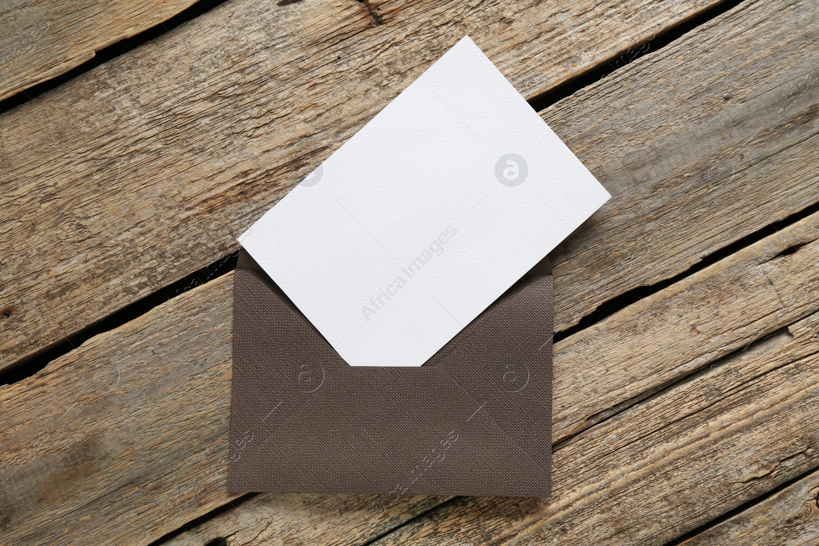 Blank invitation card and envelope on wooden table, top view. Space for design Photo of Blank invitation card and envelope on wooden table, top view. Space for design