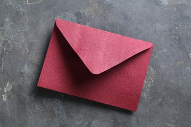 Photo of Beautiful invitation envelope on grey table, top view