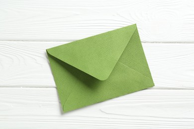 Photo of Beautiful invitation envelope on white wooden table, top view