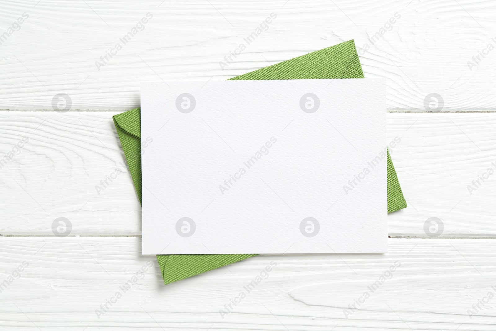 Blank invitation card and envelope on white wooden table, top view. Space for design Photo of Blank invitation card and envelope on white wooden table, top view. Space for design