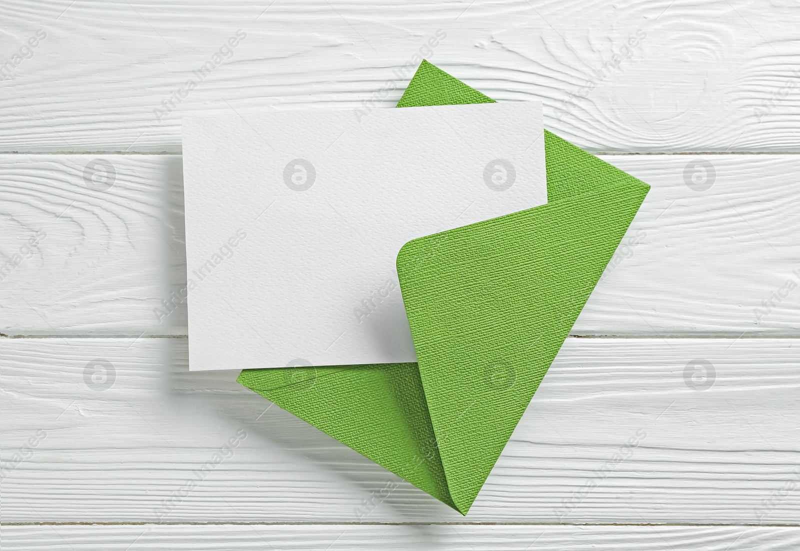 Blank invitation card and envelope on white wooden table, top view. Space for design Photo of Blank invitation card and envelope on white wooden table, top view. Space for design