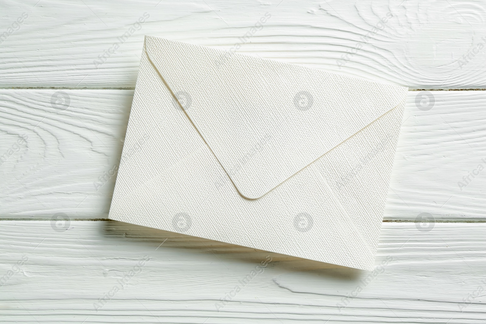 Beautiful invitation envelope on white wooden table, top view Photo of Beautiful invitation envelope on white wooden table, top view