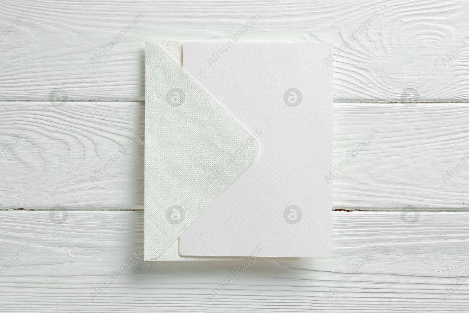 Blank invitation card and envelope on white wooden table, top view. Space for design Photo of Blank invitation card and envelope on white wooden table, top view. Space for design