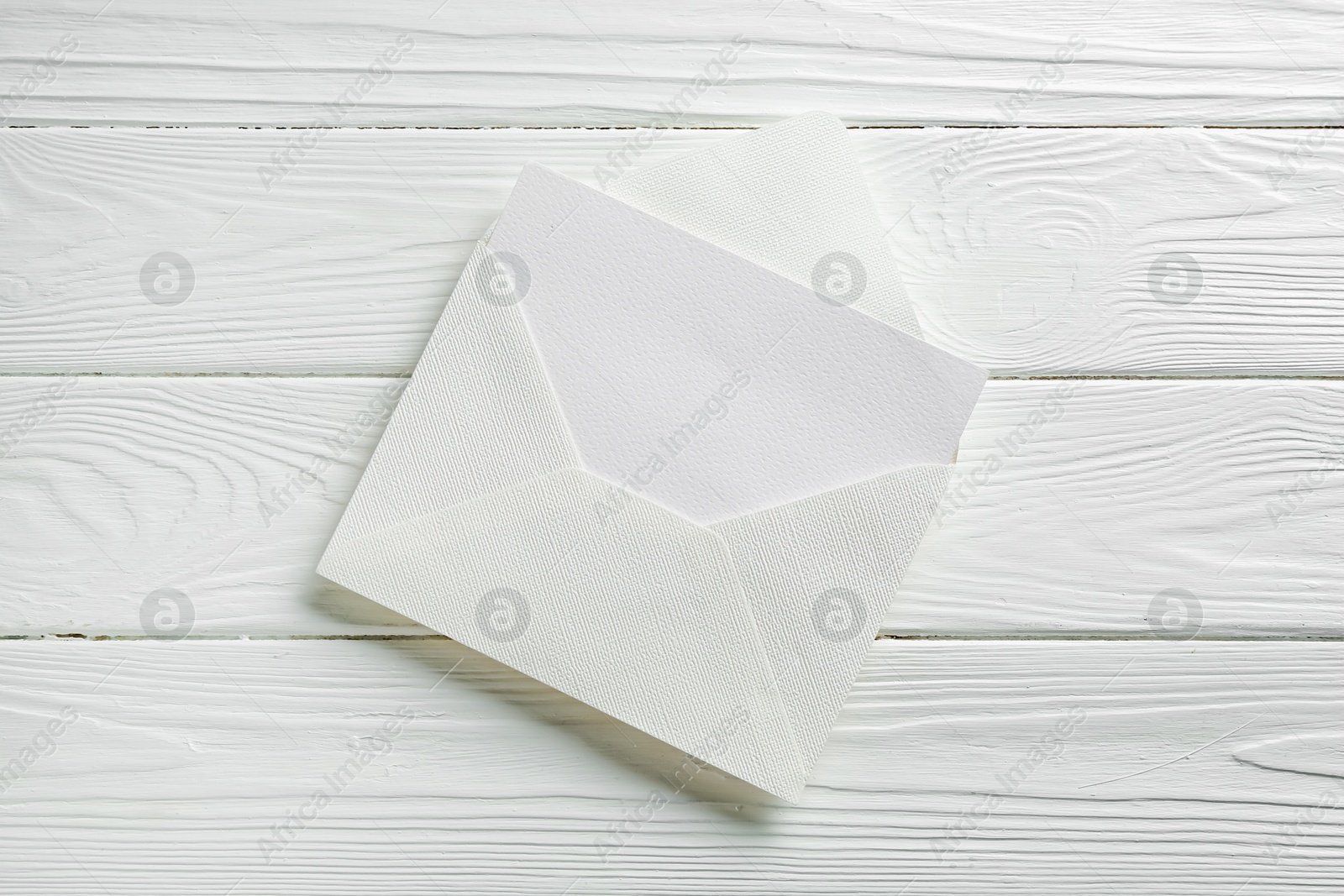 Blank invitation card and envelope on white wooden table, top view Photo of Blank invitation card and envelope on white wooden table, top view