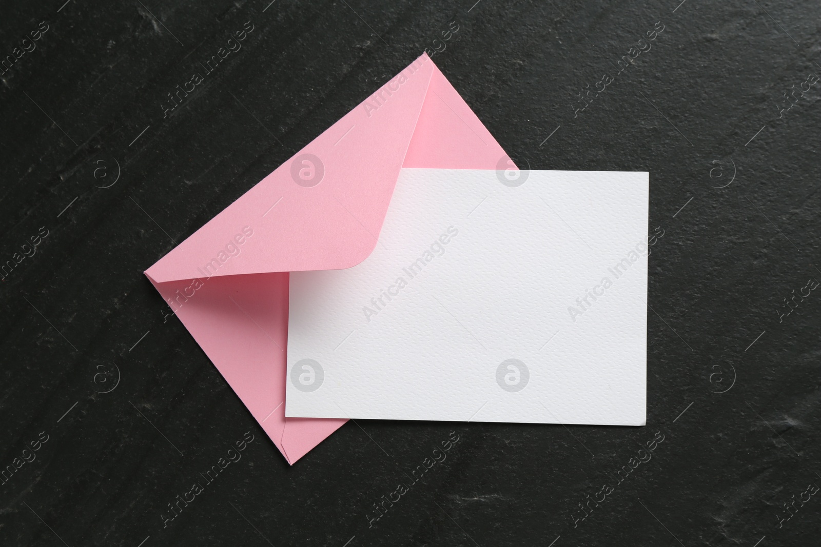 Blank invitation card and envelope on black table, top view. Space for design Photo of Blank invitation card and envelope on black table, top view. Space for design
