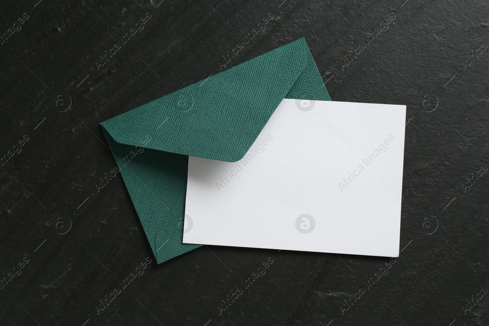 Blank invitation card and envelope on black table, top view. Space for design Photo of Blank invitation card and envelope on black table, top view. Space for design