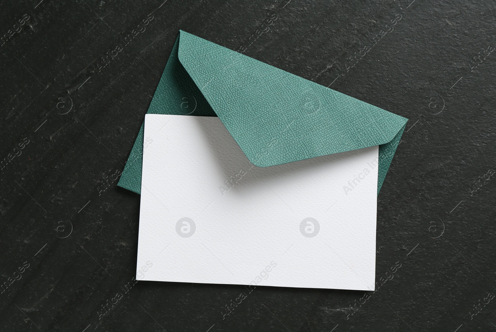 Blank invitation card and envelope on black table, top view. Space for design Photo of Blank invitation card and envelope on black table, top view. Space for design