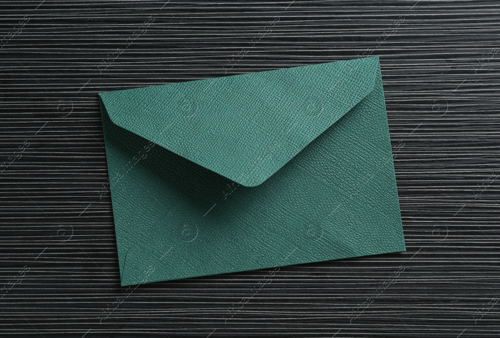 Beautiful invitation envelope on black textured table, top view Photo of Beautiful invitation envelope on black textured table, top view