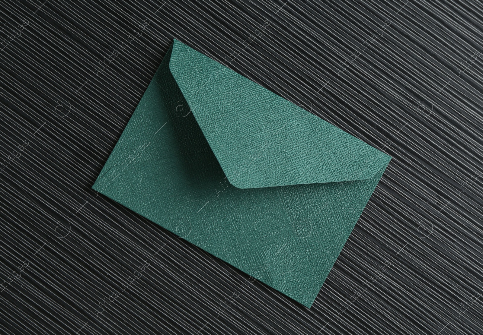 Beautiful invitation envelope on black textured table, top view Photo of Beautiful invitation envelope on black textured table, top view