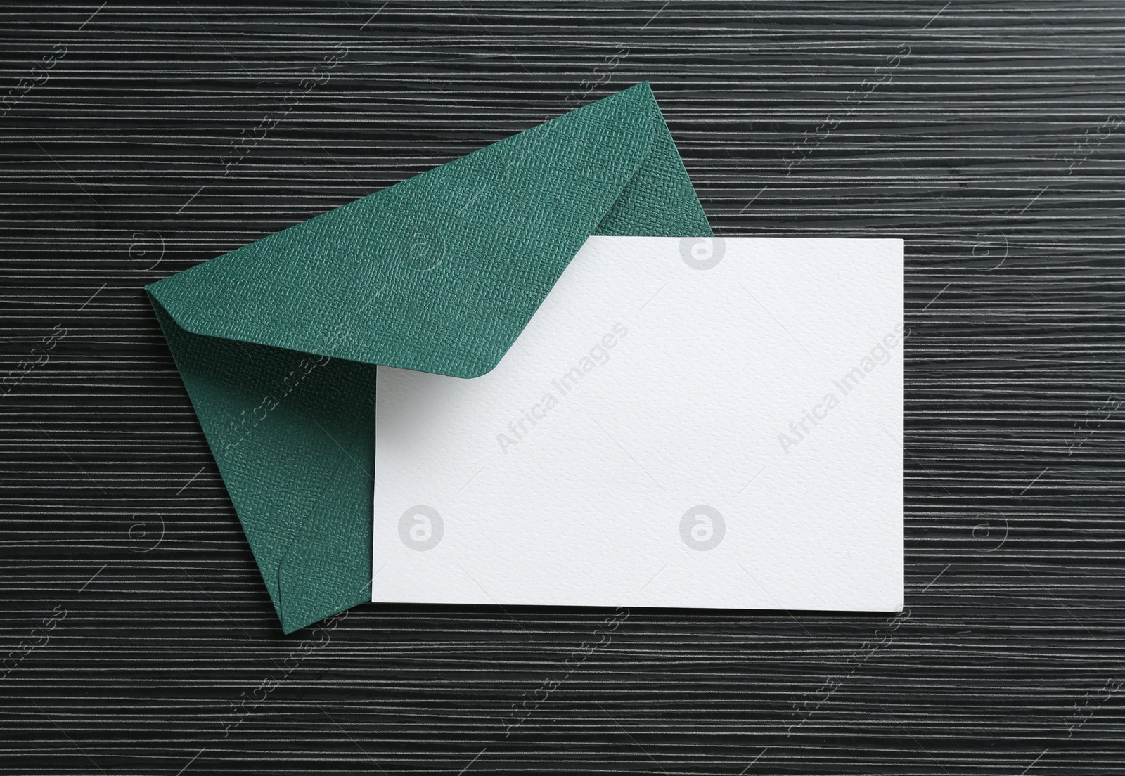 Blank invitation card and envelope on black textured table, top view. Space for design Photo of Blank invitation card and envelope on black textured table, top view. Space for design