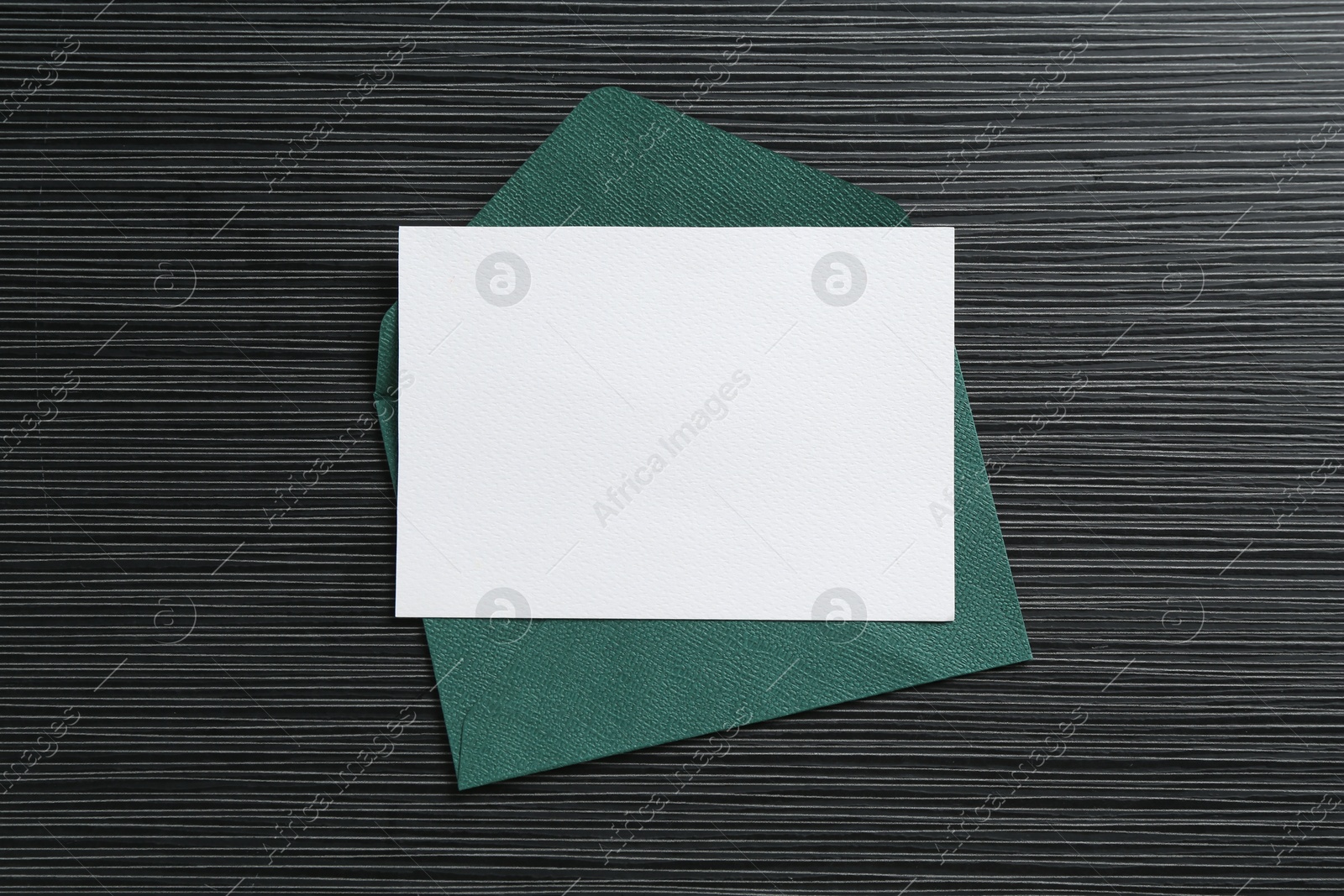 Blank invitation card and envelope on black textured table, top view. Space for design Photo of Blank invitation card and envelope on black textured table, top view. Space for design