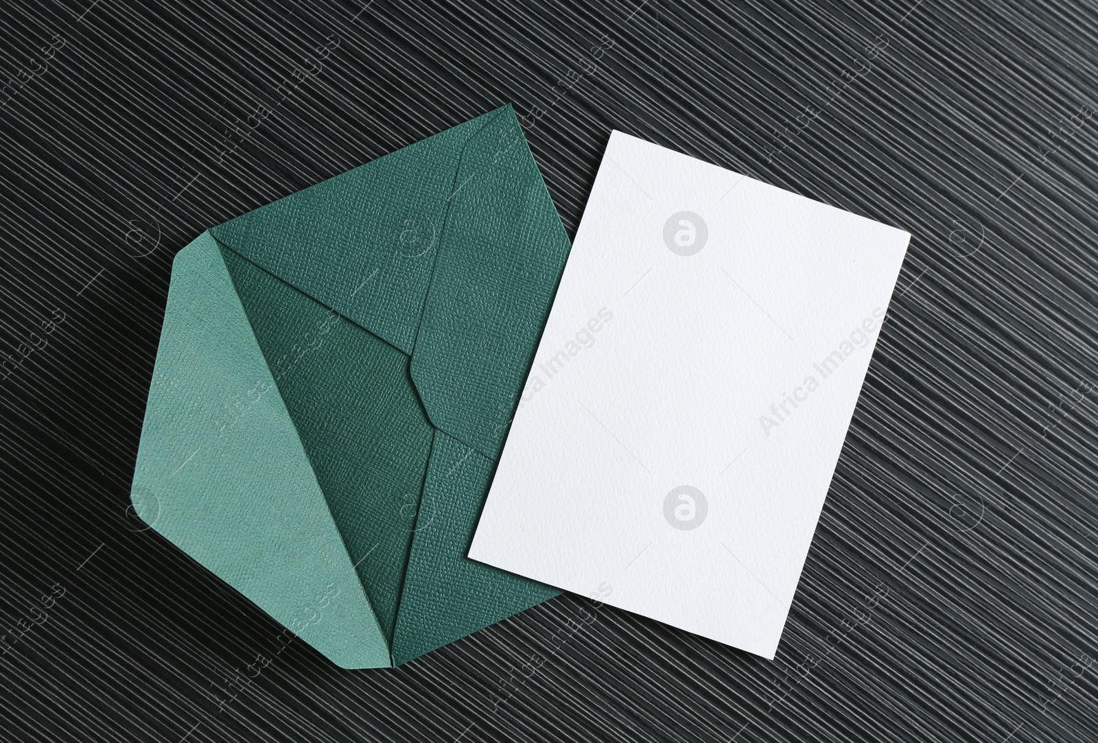 Blank invitation card and envelope on black textured table, top view. Space for design Photo of Blank invitation card and envelope on black textured table, top view. Space for design